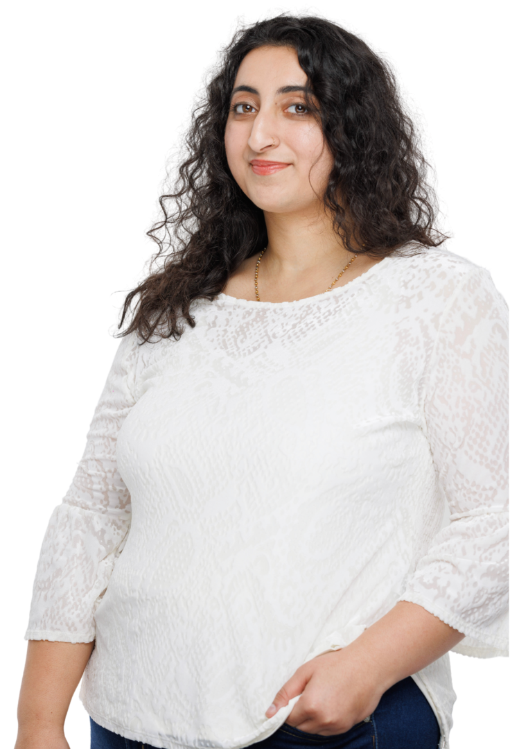 South Asian female therapist in Atlanta, Georgia, radiating warmth in a white top and jeans, offering therapeutic services for anxiety and stress management.