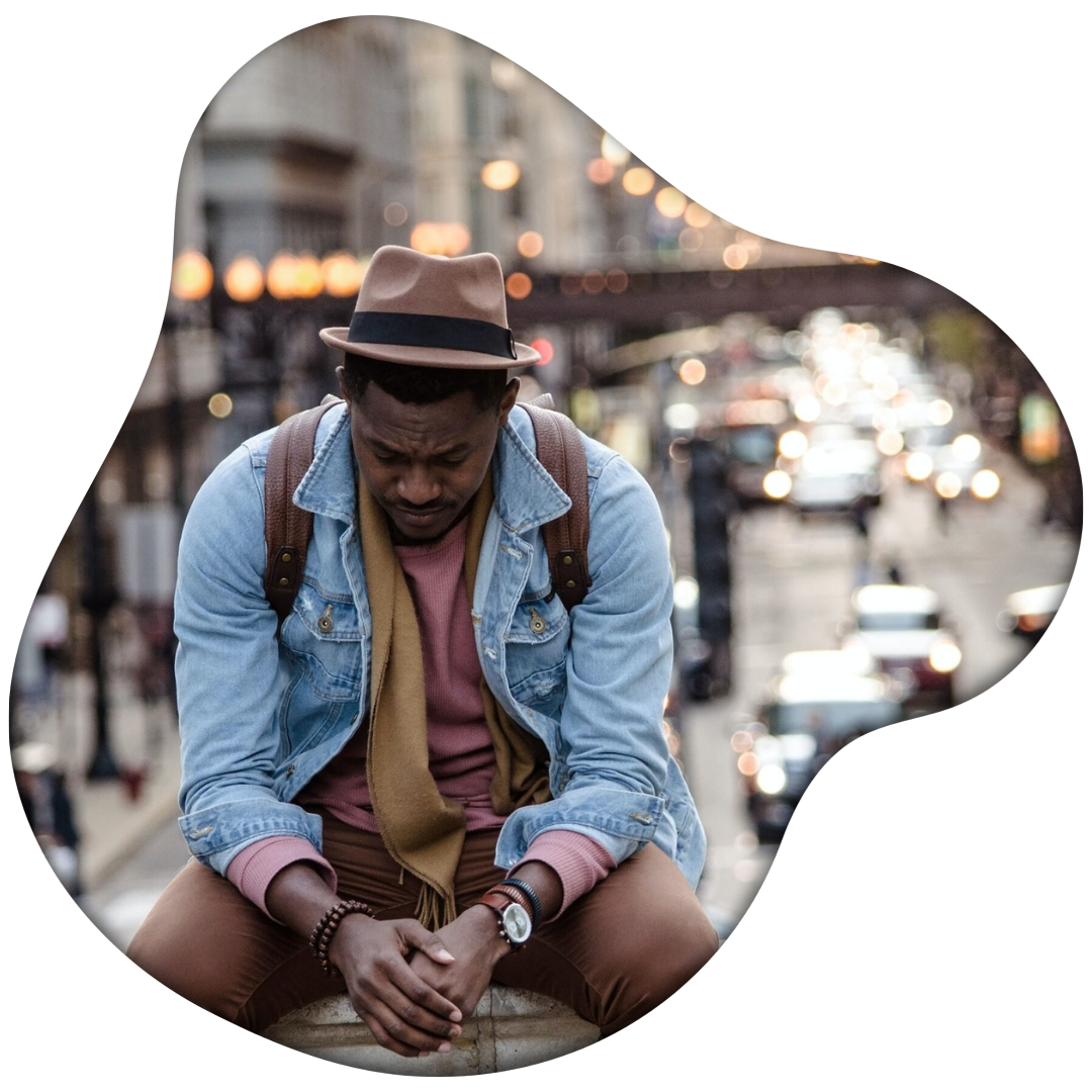 Untitled design (12) Image of a Black man sitting outside on a raised ledge. Representing someone who is showing signs of grief and could benefit of support of an Atlanta grief counselor. Where with grief counseling he can feel better.
