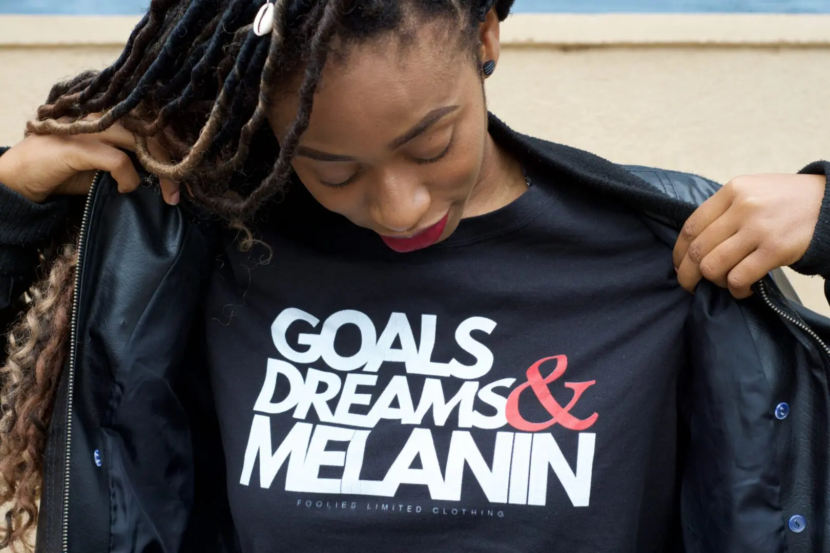 goals, dreams, & melanin | black female therapy in Atlanta | black female therapists in Atlanta, GA | Women of color therapy in Atlanta | 30263 | 30044 | 30179 Image of a woman wearing a shirt saying "goals dreams & melanin" which is similar to the empowerment that is given in black female therapy. Women of color therapy in Atlanta with black female therapists can help you embrace your identity, voice, & culture.