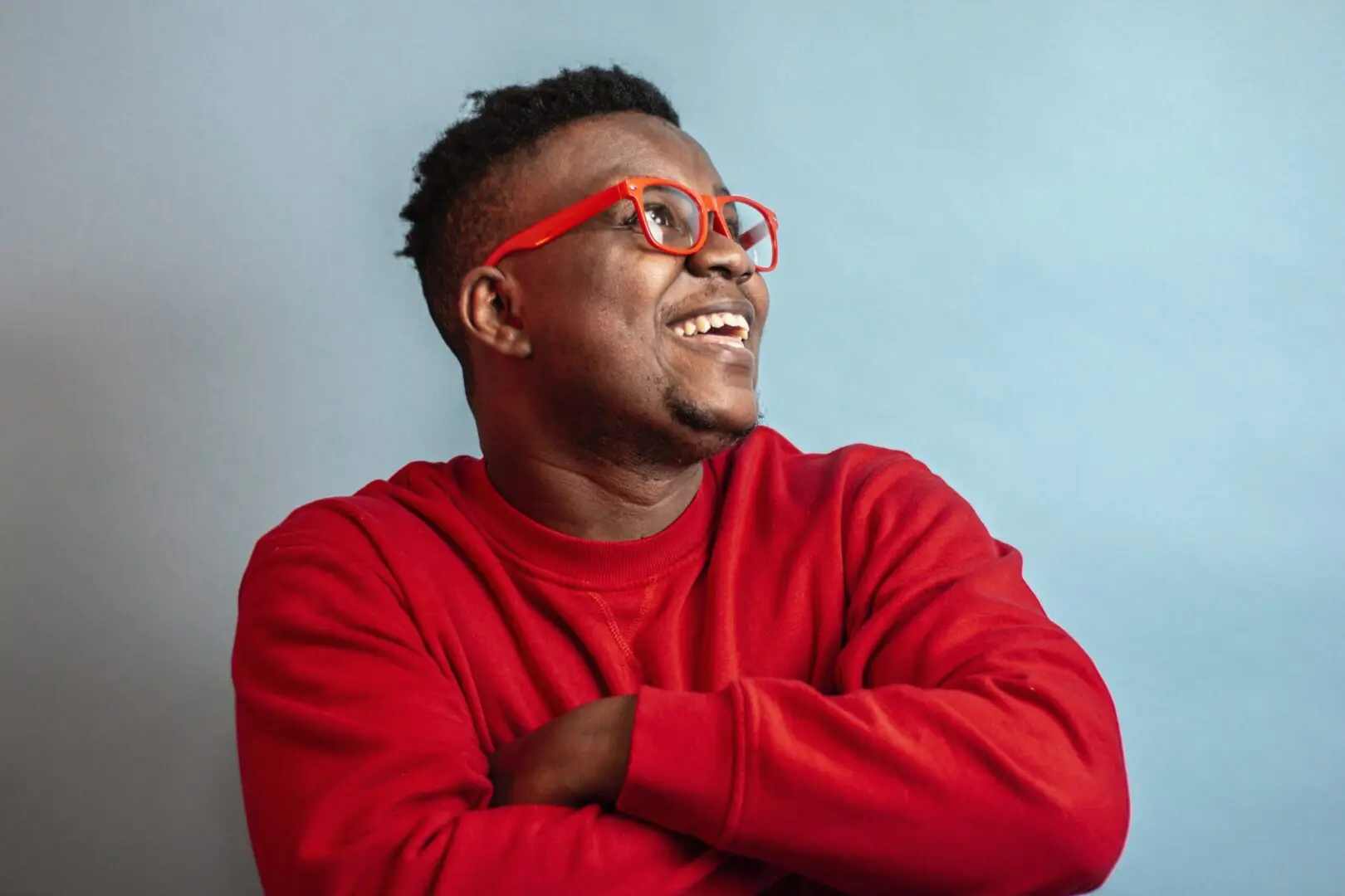 red sweater | black therapist in Atlanta | therapy for African American males in Atlanta | black male therapist near me | 30135 | 30004 | 30034 Image of a smiling black man. Representing the benefits that can come from meeting with a black therapist in Atlanta. Get support from a black male therapist in therapy for African American males in Atlanta, GA.
