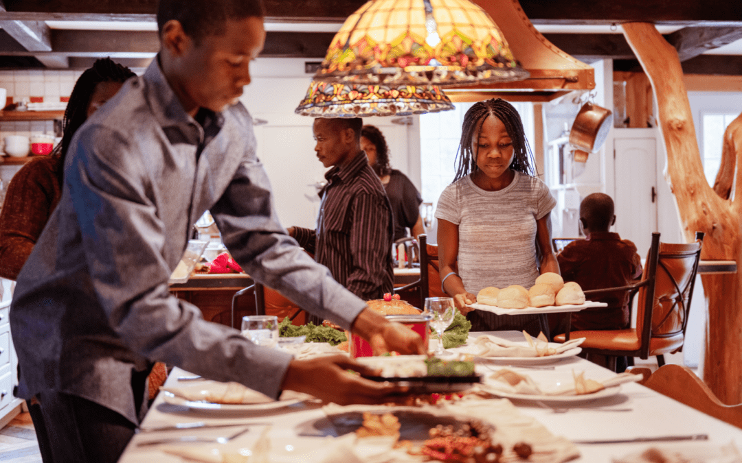 Black family in the kitchen preparing a holiday meal, with an emphasis on mental health and reducing stress during the holiday season