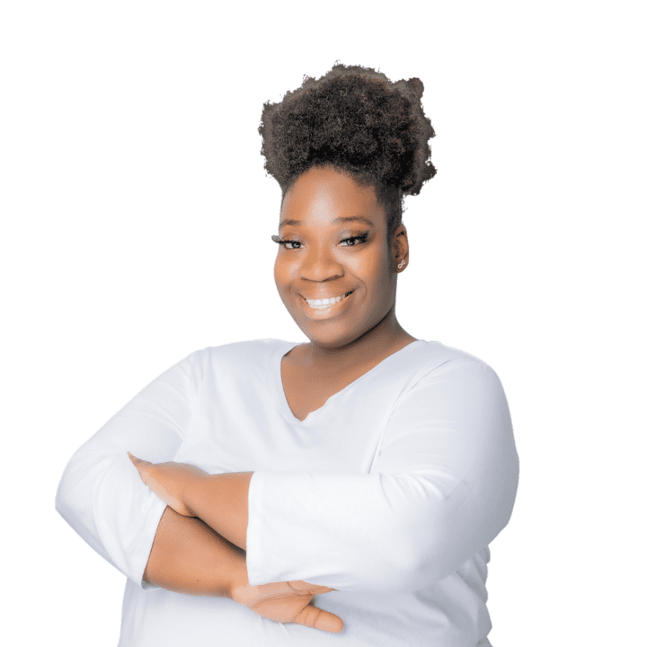 Smiling Black woman EMDR therapist with natural hair, wearing a white top, in her Atlanta, Georgia office, specializing in trauma therapy and emotional support.