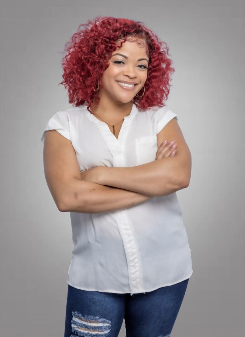 Smiling Black female therapist with red hair wearing white shirt specializing in accountability and women’s issues in Atlanta.