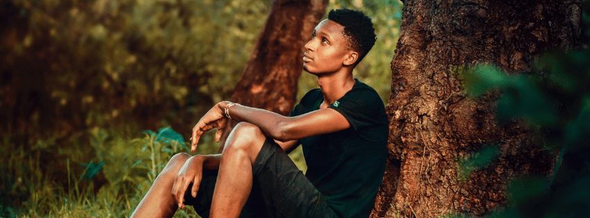 Image of an african american man sitting in a forest. Representing someone that may benefit from therapy with a black female therapist in Atlanta, GA. Be your authentic self.