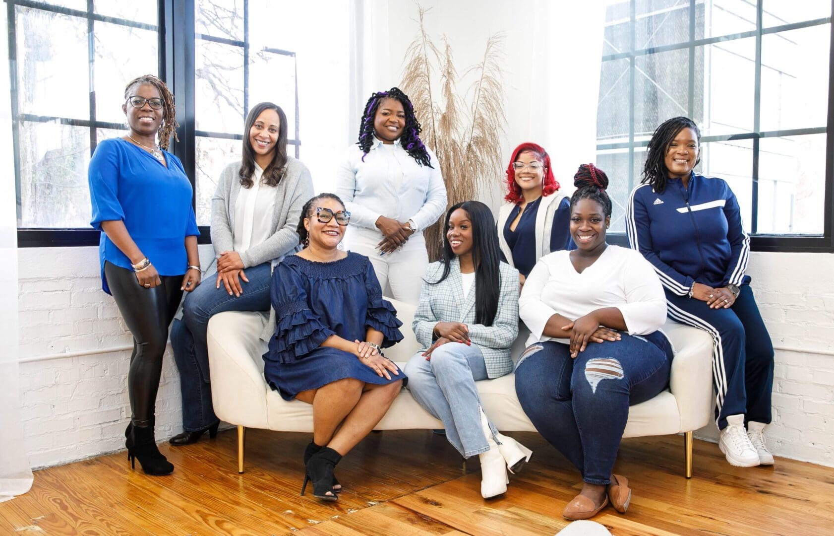 Eight Black Therapists wearing blue and white posing for photo in natural light. Representing Simplicity Psychotherapy group practice for Black men and women