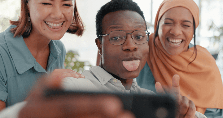 Business people, face and happy office selfie, solidarity or diversity for team building. Startup staff group, smartphone or friends photo with funny, excited and teamwork support with islamic woman, Black man, and asian woman