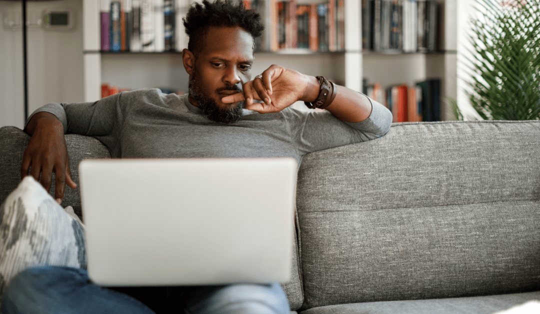 Young African American man speaking to a therapist on laptop at home