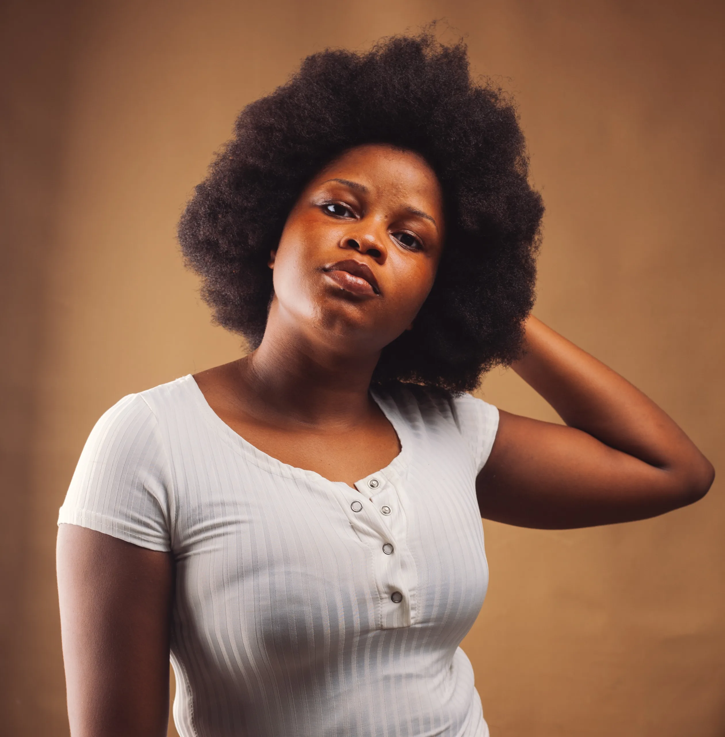 A close-up of a Black woman's face, her furrowed brows and worried expression conveying feelings of stress and anxiety.