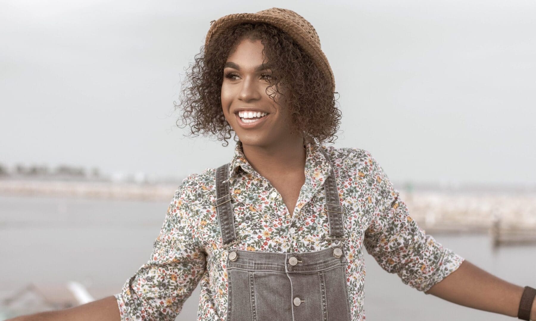 Image of a black trans woman smiling standing in front of water. Representing someone who could benefit from LGBTQ therapy in Atlanta, GA. Whether for depression or anxiety an LGBTQ therapist can give support to you through LGBTQIA therapy.