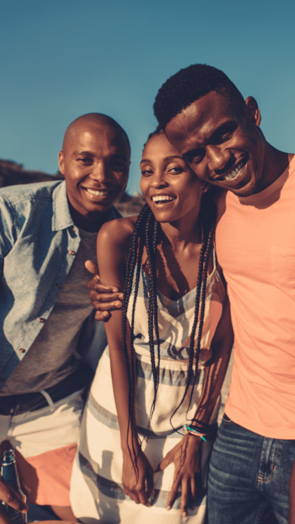 A group of joyful friends laughing and hugging, symbolizing authentic relationships and living in alignment with personal values.