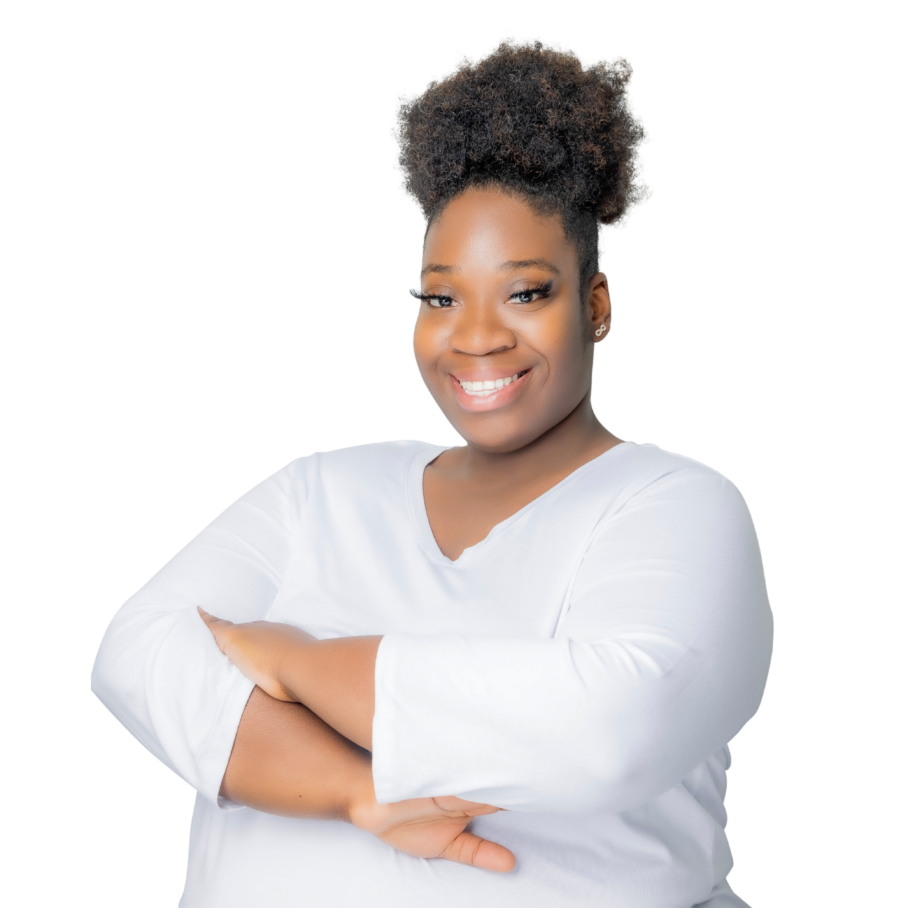 Smiling Black woman therapist with natural hair, wearing a white top, in her Atlanta, Georgia office, specializing in trauma therapy and emotional support.